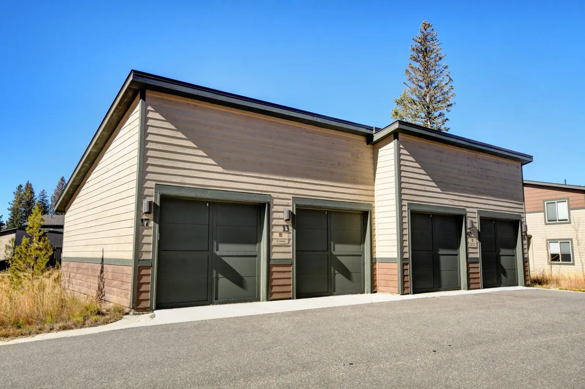 The exterior of the property, showing garage doors, well-maintained landscaping, and contemporary siding. The practical space hints at access to outdoor adventures and the quiet, upscale character of the neighborhood.